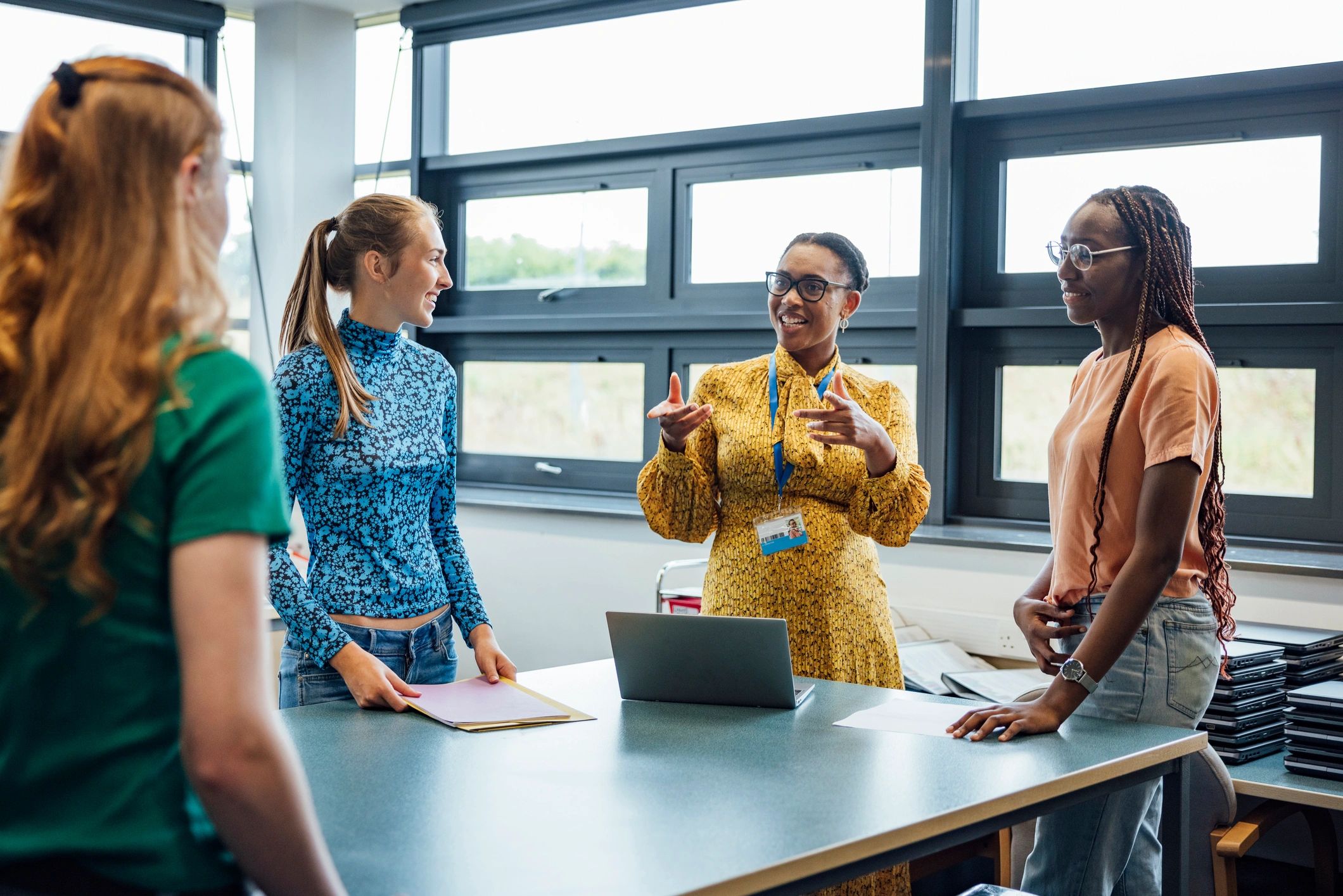 Teacher speaking with students in a classroom